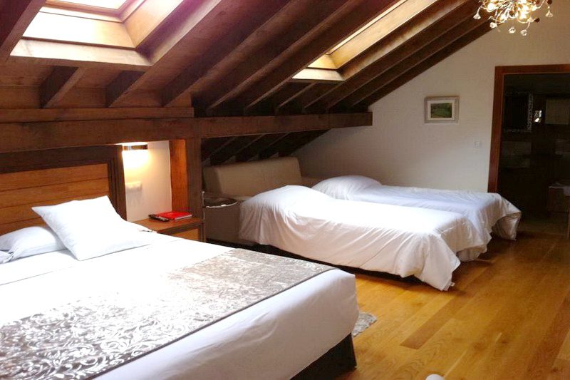 Habitación abuhardillada con dos camas de Hotel Suites Valles Pasiegos